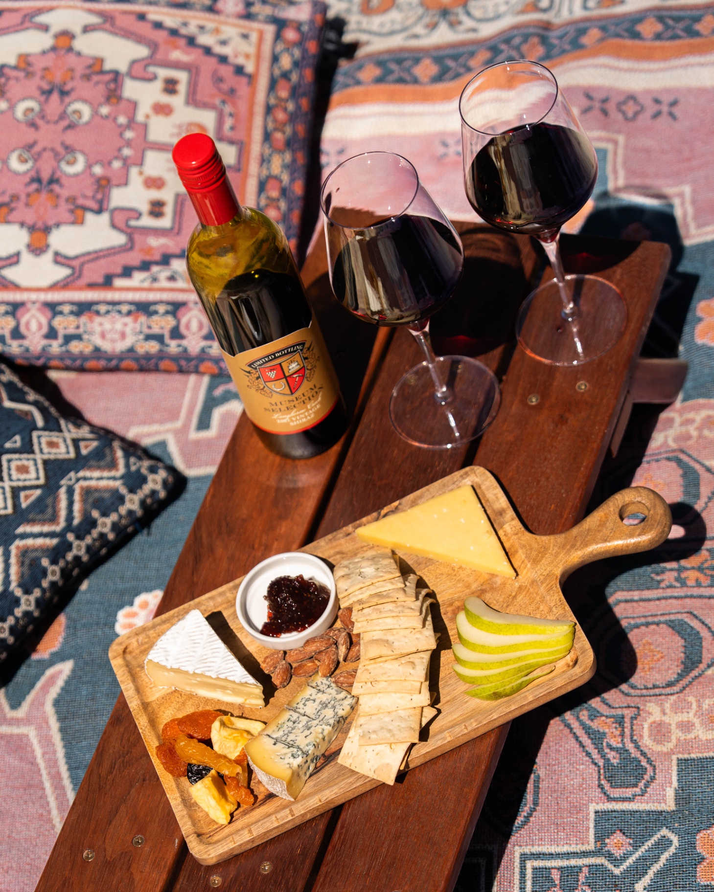 Cheese and wine board on a sunlit rug