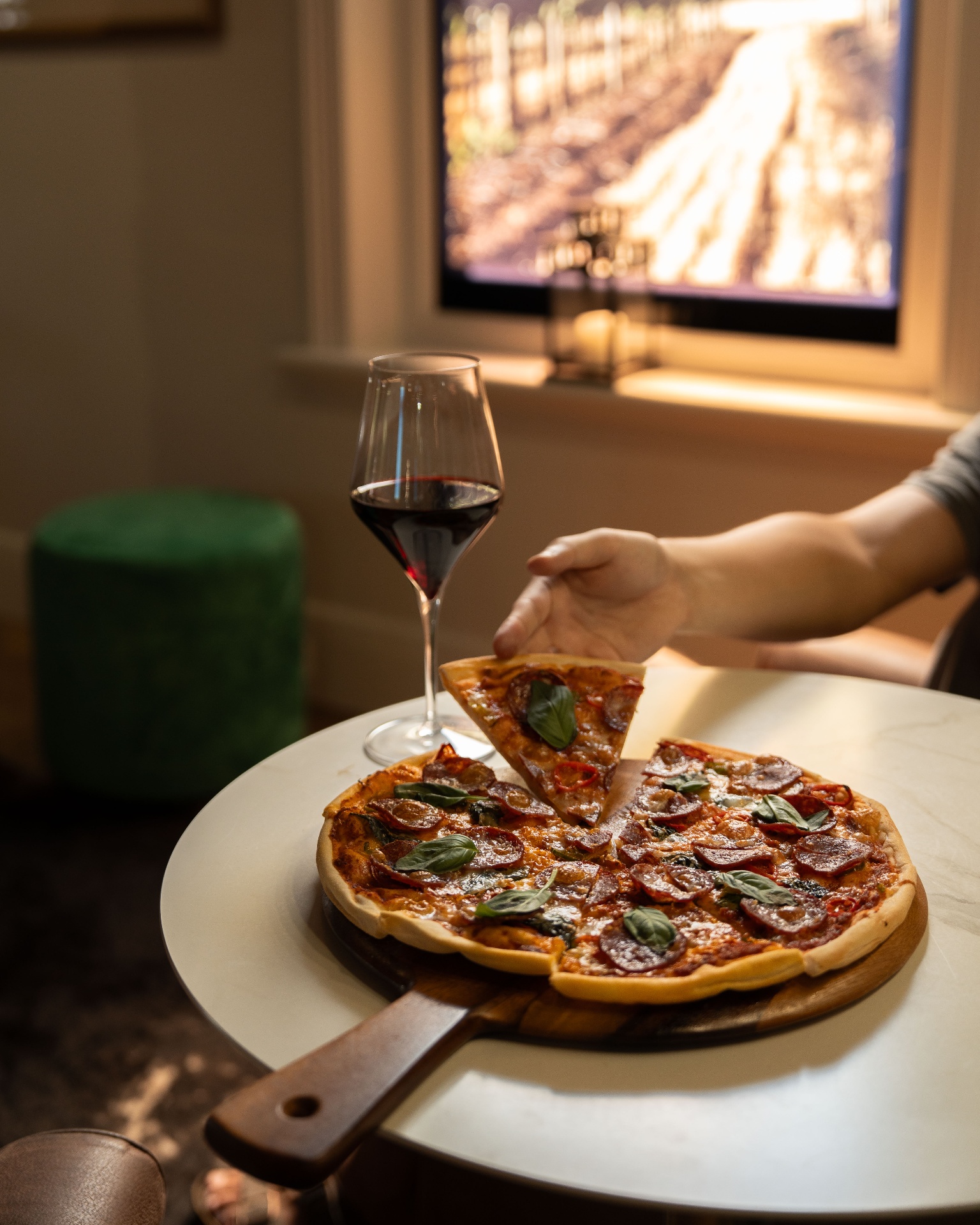 Wood-fired pizza with a glass of red wine